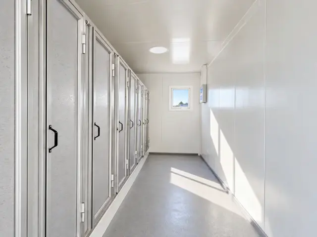 Pasillo interior del módulo de seis duchas, con las cabinas a un costado