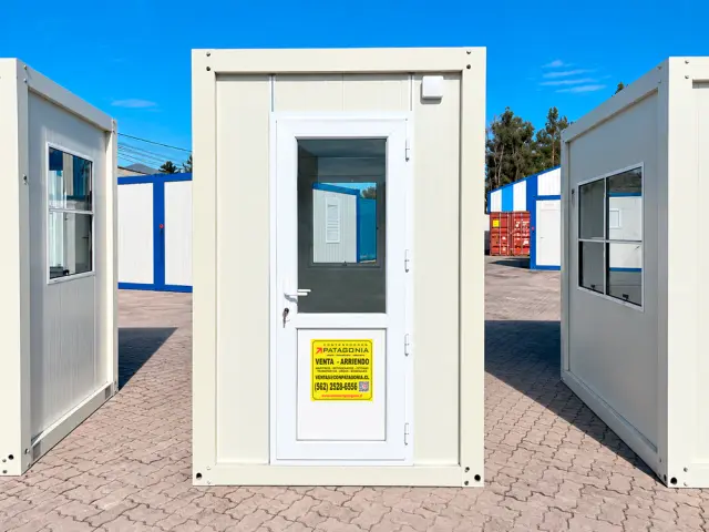 La puerta vista de frente, con la caseta de perfil a cada lado y el cartel de venta y arriendo