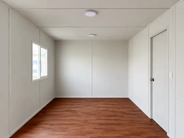 Interior forrado con la puerta del medio baño cerrada a un costado, piso vinílico oscuro y plafones LED en el cielo