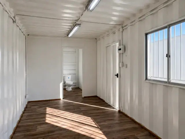 Vano del baño abierto con el WC a la vista, en un interior sin forrar donde el corrugado queda expuesto