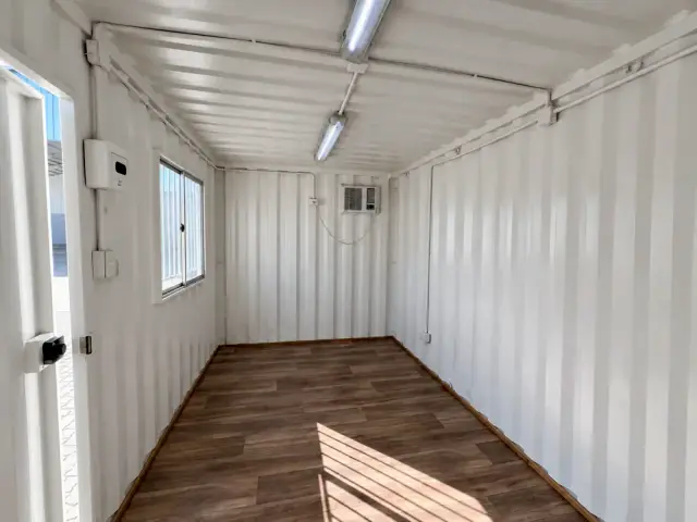 Interior sin forrar con el equipo de aire acondicionado, tubo LED, ventana corredera y la puerta de acceso abierta