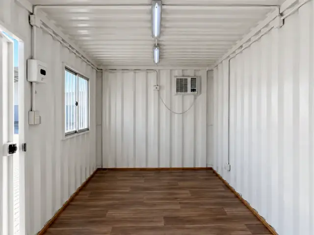 Interior sin forrar con el corrugado a la vista, equipo de aire acondicionado, tubos LED y piso vinílico símil madera