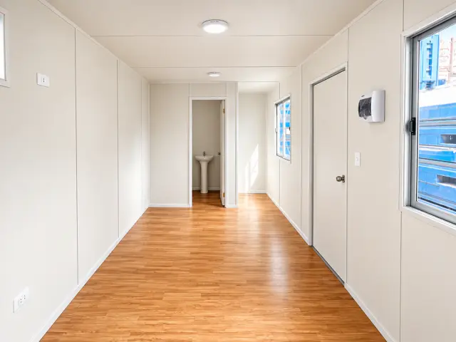 Interior mirando al fondo: el recinto de trabajo a la izquierda, la puerta del medio baño a la derecha y el lavamanos al fondo