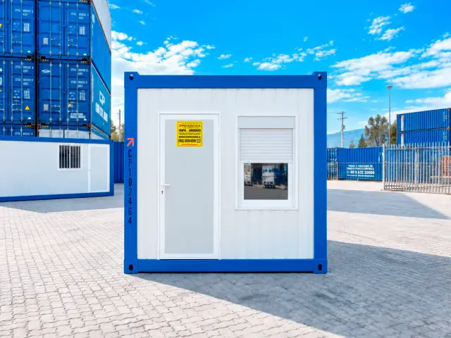 Frente de la oficina de 10 pies: puerta blanca con su cartel y ventana con la cortina metálica enrollable bajada