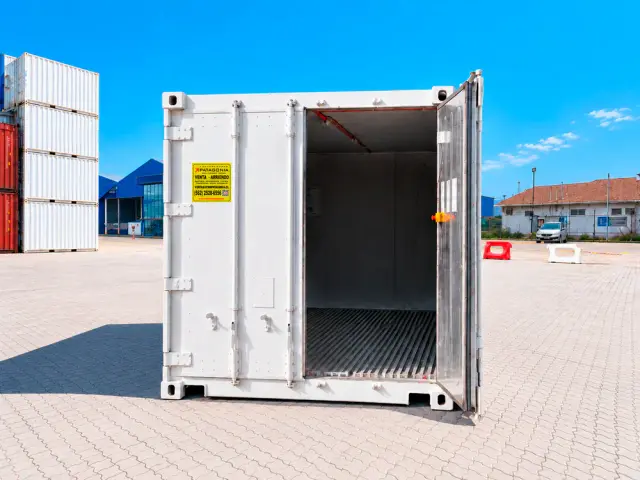 Caja reefer de 20 pies con una hoja abierta, mostrando el piso ranurado de aluminio