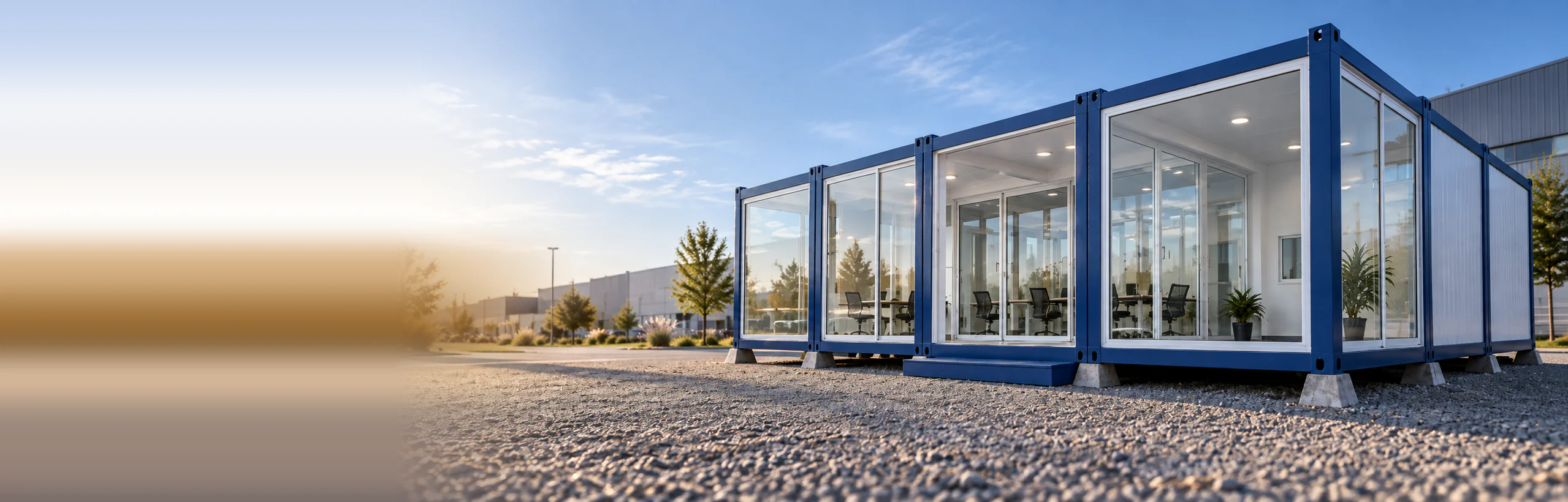 Planta de oficinas modulares de fachada vidriada, acopladas y apoyadas sobre soportes de hormigón prefabricados en una explanada de gravilla